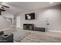 Open-concept living room with modern entertainment center, neutral colors, and hardwood flooring at 3432 E Bartlett Dr, Gilbert, AZ 85234