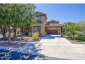 Attractive two-story home featuring a spacious driveway, porte-cochere, and desert-style landscaping at 3649 E Hutchins Ct, Gilbert, AZ 85295