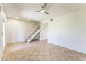 Bright living room featuring neutral walls, tiled floors, a modern ceiling fan, and a staircase at 3930 W Monterey St # 136, Chandler, AZ 85226