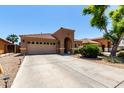 Lovely single-story house with a tile roof, an arched entryway, a desert front yard, and a long driveway leading to a garage at 3935 E Graphite Rd, San Tan Valley, AZ 85143