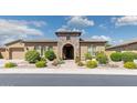 Charming home exterior featuring a stone archway, manicured landscaping, and a well-maintained yard at 5330 S Big Horn Pl, Chandler, AZ 85249