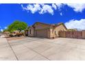 Exterior showcasing the home's architectural style, desert landscaping, and spacious driveway at 5635 W Pecan Rd, Laveen, AZ 85339