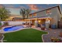 An outdoor haven featuring a sparkling pool, inviting lounge area, and a covered patio with ambient lighting at 5919 S Banning St, Gilbert, AZ 85298