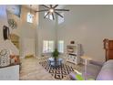 Open concept living room with two story ceilings, tile flooring, large ceiling fan, and modern furnishings at 6570 S Pewter Way, Chandler, AZ 85249