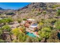 An aerial view of a desert estate showcasing a sparkling pool, lush landscaping, and red tile roof at 7131 N 40Th St, Paradise Valley, AZ 85253