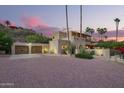 Exterior evening shot featuring the home's garage, terracotta roofing, desert landscaping and large brick driveway at 7131 N 40Th St, Paradise Valley, AZ 85253