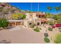 Beautiful exterior of a desert home featuring a porte cochere, terracotta roofing, mature landscaping and a circular driveway at 7131 N 40Th St, Paradise Valley, AZ 85253