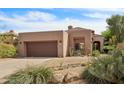 Single-level home with desert landscaping, a two-car garage, and tile roof at 7169 E Bramble Berry Ln, Scottsdale, AZ 85266