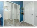 Well-lit bathroom featuring a modern design with gray tile flooring, a blue accent wall, and a large mirror over the vanity at 7204 S Golfside Ln, Phoenix, AZ 85042