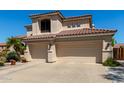 View of the front of the home featuring a three car garage and tile roof at 7242 W Aurora Dr, Glendale, AZ 85308