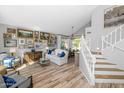 Bright living room with staircase, wood floors, abundant artwork, and view to the dining area at 15020 S 25Th St, Phoenix, AZ 85048