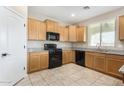 Bright kitchen with ample cabinetry, granite counters, and stainless sink and black appliances at 17425 W Willow Ave, Surprise, AZ 85388