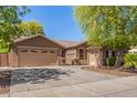 Warm single-story home featuring a three car garage and a well-manicured yard at 18492 E Oak Hill Ln, Queen Creek, AZ 85142