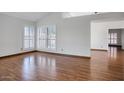Spacious living room featuring hardwood floors and plantation shutters at 18802 N 71St Ln, Glendale, AZ 85308