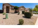 Front view of a single-story home with gravel landscaping and green bushes at 21563 N Greenway Rd, Maricopa, AZ 85138