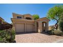 Beautiful two-story home with a three-car garage, mature landscaping, and a brick driveway at 2406 N 142Nd Ave, Goodyear, AZ 85395