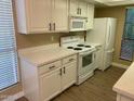 Well-lit kitchen features white cabinets and appliances, complemented by sleek countertops and modern fixtures at 3131 W Cochise Dr # 218, Phoenix, AZ 85051