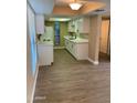 Updated kitchen boasts white cabinets, counters and appliances with modern flooring and ample natural light, creating a welcoming space at 3131 W Cochise Dr # 218, Phoenix, AZ 85051