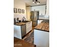 Stylish kitchen featuring white cabinets, butcher block countertops, and stainless steel appliances at 3314 N 68Th St # 107, Scottsdale, AZ 85251