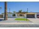 Modern home featuring neutral paint, desert landscaping and a dark finished garage door at 47 Spur Cir, Scottsdale, AZ 85251