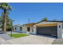 Single Gathering home with minimalist landscaping and a modern dark garage door at 47 Spur Cir, Scottsdale, AZ 85251