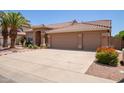 Charming home exterior featuring a wide driveway leading to a spacious garage with a well-kept lawn at 623 W Harvard Ave, Gilbert, AZ 85233