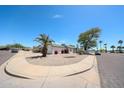 Single-story home with desert landscaping, mature trees, and circular driveway at 8521 W Mauna Loa Ln, Peoria, AZ 85381