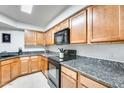 Well-lit kitchen boasts wooden cabinets, granite countertops, and black appliances at 8787 E Mountain View Rd # 1029, Scottsdale, AZ 85258