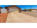 Wide driveway leading to a two-car garage, complemented by low-maintenance landscaping at 9118 W Cameron Dr, Peoria, AZ 85345