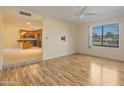 Bright living room with hardwood flooring offering ample space and a window, flowing to the open kitchen at 9463 E Jenan Dr, Scottsdale, AZ 85260