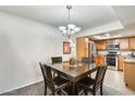 Cozy dining area adjacent to the kitchen with wood table and dark wood chairs under a chandelier at 9990 N Scottsdale Rd # 2042, Paradise Valley, AZ 85253