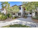 Condo exterior with red tile roof, mature landscaping, covered stairs, and light-colored walls at 9990 N Scottsdale Rd # 2042, Paradise Valley, AZ 85253