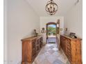 Elegant foyer with stone floors, wooden cabinets, and an open doorway to the exterior at 10182 E Gilded Perch Dr, Scottsdale, AZ 85255