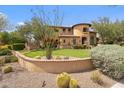 Southwestern home showcasing desert landscaping with cacti and a curving retaining wall at 10182 E Gilded Perch Dr, Scottsdale, AZ 85255