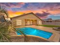 Inviting backyard featuring a sparkling pool, artificial turf and a covered patio at 10809 W Harmony Ln, Peoria, AZ 85373