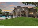 Expansive backyard featuring a sparkling pool, lush lawn, covered patio, and outdoor grill area at 1181 N Dustin Ln, Chandler, AZ 85226