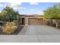 Beautiful home with a well-maintained front yard, desert plants and a large driveway at 12972 W Kokopelli Dr, Peoria, AZ 85383
