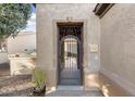 Close up of front door with decorative iron gate and desert landscaping at 12972 W Kokopelli Dr, Peoria, AZ 85383