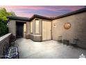 Outdoor patio with neutral walls and decorative wall hangings at dusk at 12972 W Kokopelli Dr, Peoria, AZ 85383