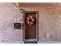 View of front door with a decorative wreath and a visible unit number in the Four Peaks condominium community at 13700 N Fountain Hills Blvd # 155, Fountain Hills, AZ 85268