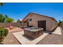 Relaxing backyard oasis with a hot tub, covered patio, and lush desert landscaping at 174 W Del Rio St, Gilbert, AZ 85233