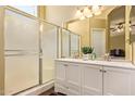 Bright bathroom featuring a double sink vanity with white cabinets, an enclosed shower, and a mirrored backsplash at 174 W Del Rio St, Gilbert, AZ 85233
