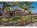 Close-up of charming home featuring mature landscaping and a rustic fence enhancing its inviting appeal at 1817 W Seldon Ln, Phoenix, AZ 85021