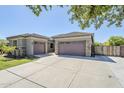 Inviting home exterior with a two-car garage, lush lawn, and a well-maintained concrete driveway at 18617 E Arrowhead Trl, Queen Creek, AZ 85142