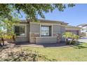 Charming home exterior showcasing well-maintained landscaping, stone accents, and manicured lawn at 18617 E Arrowhead Trl, Queen Creek, AZ 85142