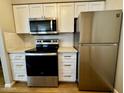 Kitchen featuring stainless steel appliances, modern cabinetry, and laminate floors at 2025 E Campbell Ave # 132, Phoenix, AZ 85016
