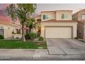Charming two-story home with a two car garage, lush landscaping, and a lovely red umbrella on the front patio at 213 E Vaughn Ave, Gilbert, AZ 85234