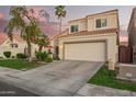 Charming two-story home with a two car garage, lush landscaping, and a lovely red umbrella on the front patio at 213 E Vaughn Ave, Gilbert, AZ 85234
