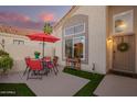 Cozy front porch with red umbrella, stylish seating, and a beautiful front door with a wreath at 213 E Vaughn Ave, Gilbert, AZ 85234