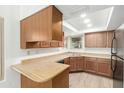 Functional kitchen with wood cabinets, laminate countertops, and sufficient counter space for meal preparation at 2455 E Broadway Rd # 39, Mesa, AZ 85204